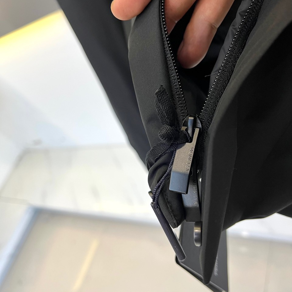 Mon蒙口（白鹅绒）、2025秋冬新品男士羽绒夹克，以经典黑色演绎高端户外机能与都市时尚的融合。这款连帽