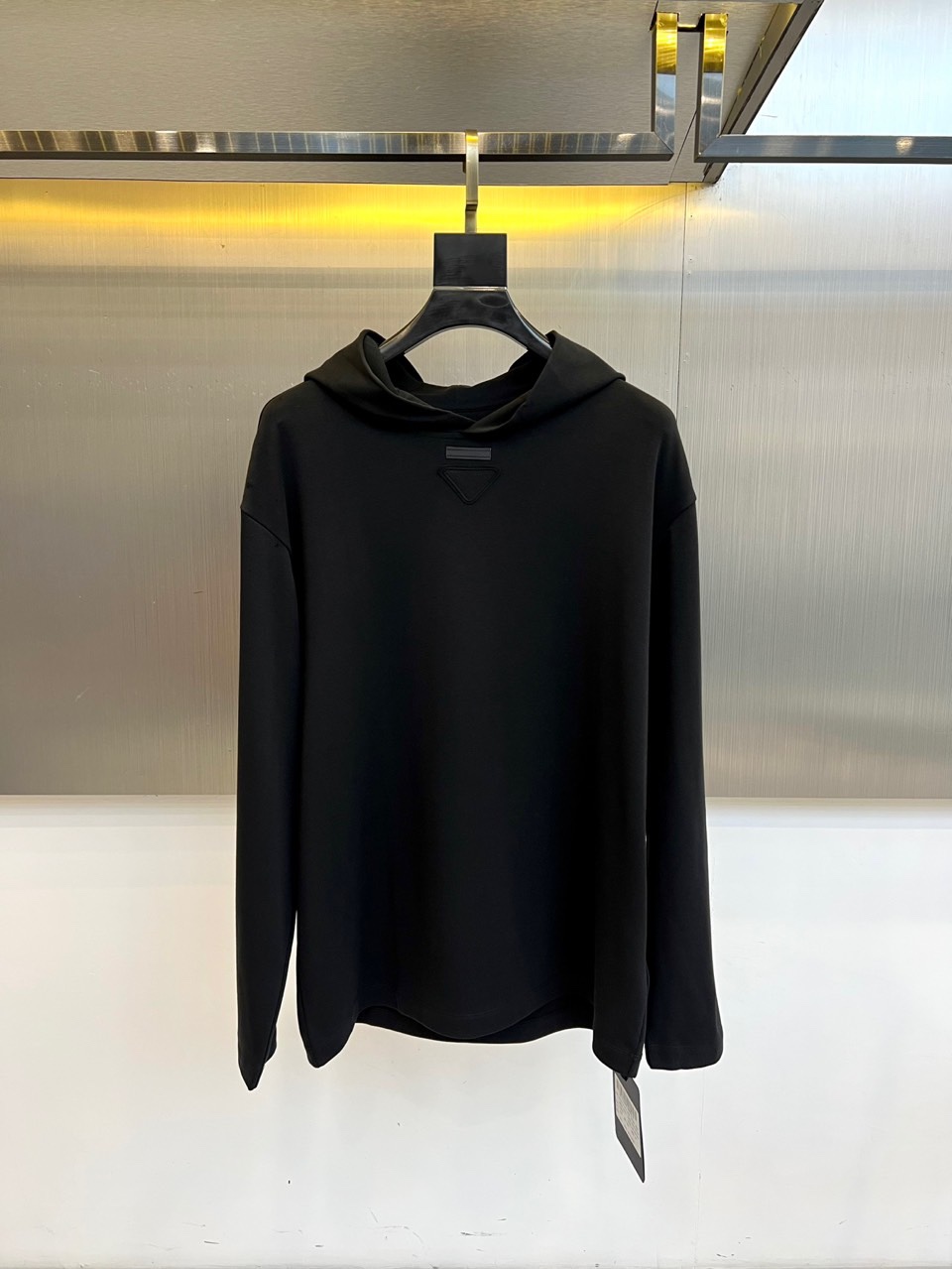 Prad普拉达、2025秋冬新品白色连帽上衣，以极简设计诠释现代奢华运动风范。款式采用宽松立体的剪裁，连