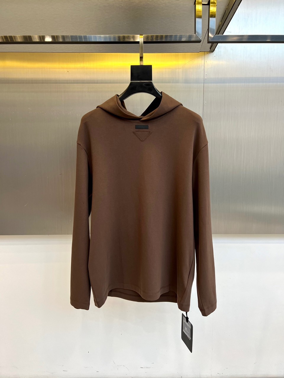 Prad普拉达、2025秋冬新品白色连帽上衣，以极简设计诠释现代奢华运动风范。款式采用宽松立体的剪裁，连