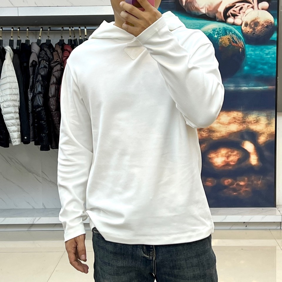 Prad普拉达、2025秋冬新品白色连帽上衣，以极简设计诠释现代奢华运动风范。款式采用宽松立体的剪裁，连