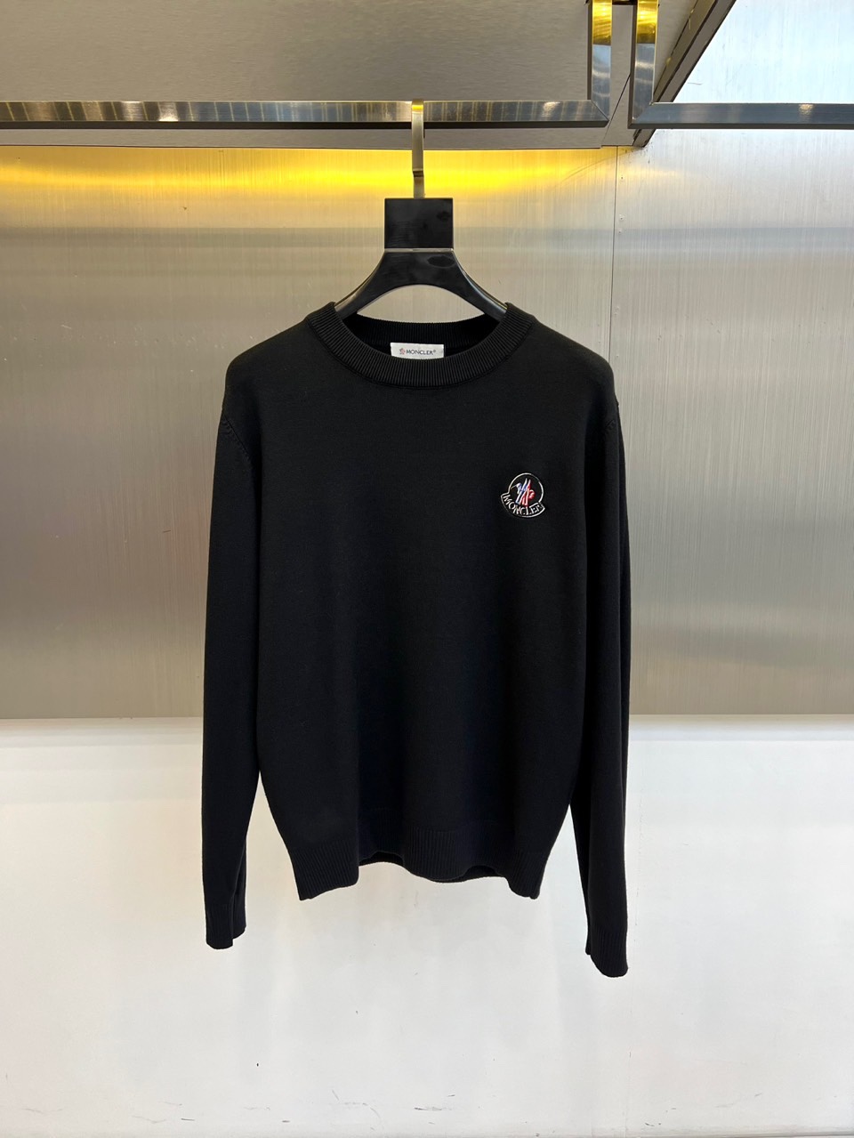 MONCLER蒙口、2025秋冬新品针织衫，以简约圆领长袖设计诠释经典优雅风格。左胸处装饰标志性品牌刺绣