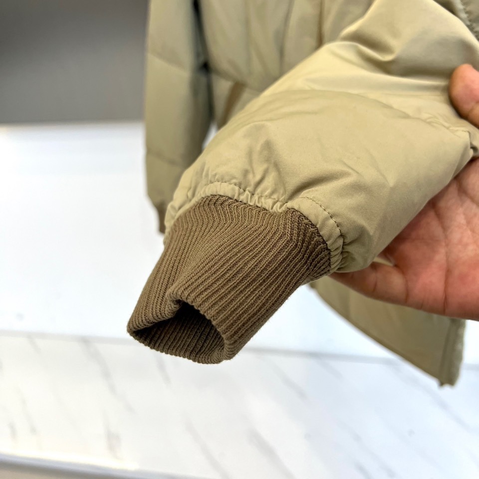 TOM FORD 2025秋冬新品男士羽绒服，以经典卡其色调诠释现代都市美学。款式采用利落的立领设计，配