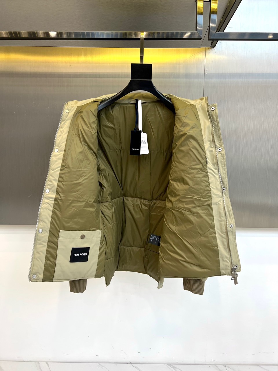 TOM FORD 2025秋冬新品男士羽绒服，以经典卡其色调诠释现代都市美学。款式采用利落的立领设计，配