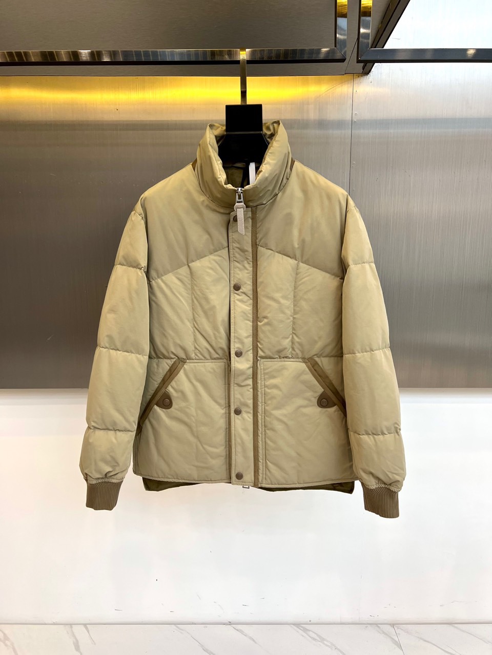 TOM FORD 2025秋冬新品男士羽绒服，以经典卡其色调诠释现代都市美学。款式采用利落的立领设计，配