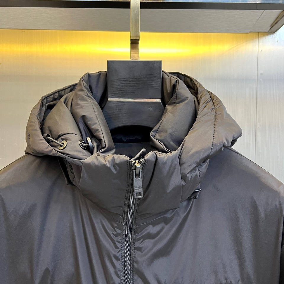 Prada普拉（鹅绒）25ss新款 连帽加厚保暖中长款连帽羽绒服外套，面料采用再生Re-Nylon环保的