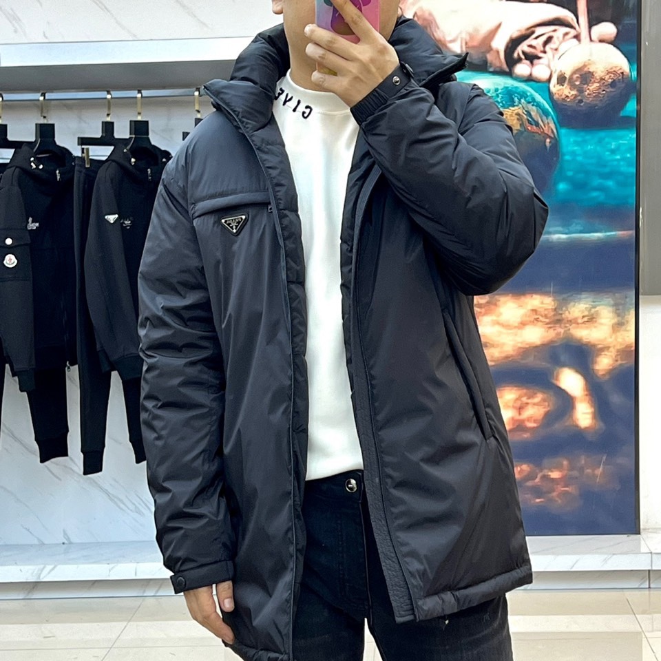 Prada普拉（鹅绒）25ss新款 连帽加厚保暖中长款连帽羽绒服外套，面料采用再生Re-Nylon环保的