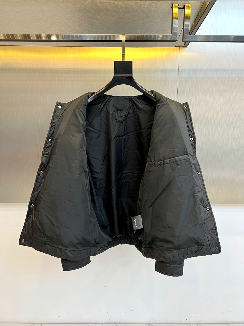 Prad普拉达、2025秋冬新款羽绒服，这款羽绒服采用翻领设计，领口处独特的编织纹理增添细腻质感，搭配品