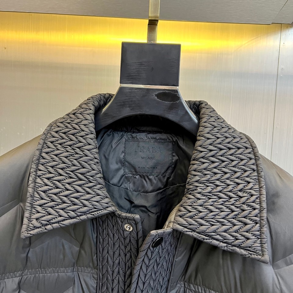 Prad普拉达、2025秋冬新款羽绒服，这款羽绒服采用翻领设计，领口处独特的编织纹理增添细腻质感，搭配品