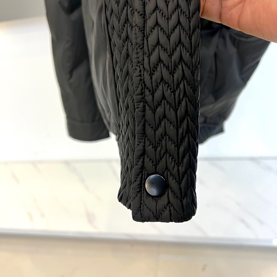 Prad普拉达、2025秋冬新款羽绒服，这款羽绒服采用翻领设计，领口处独特的编织纹理增添细腻质感，搭配品