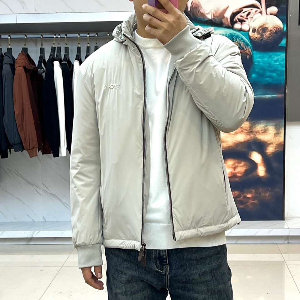 Zegna杰尼亚、2025秋冬新品羽绒服以浅灰质感演绎现代都市美学。这款连帽羽绒服采用极简立体剪裁，前襟