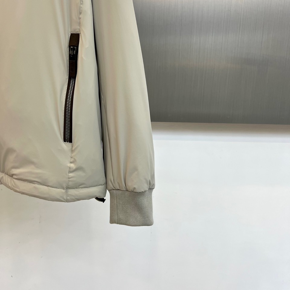 Zegna杰尼亚、2025秋冬新品羽绒服以浅灰质感演绎现代都市美学。这款连帽羽绒服采用极简立体剪裁，前襟