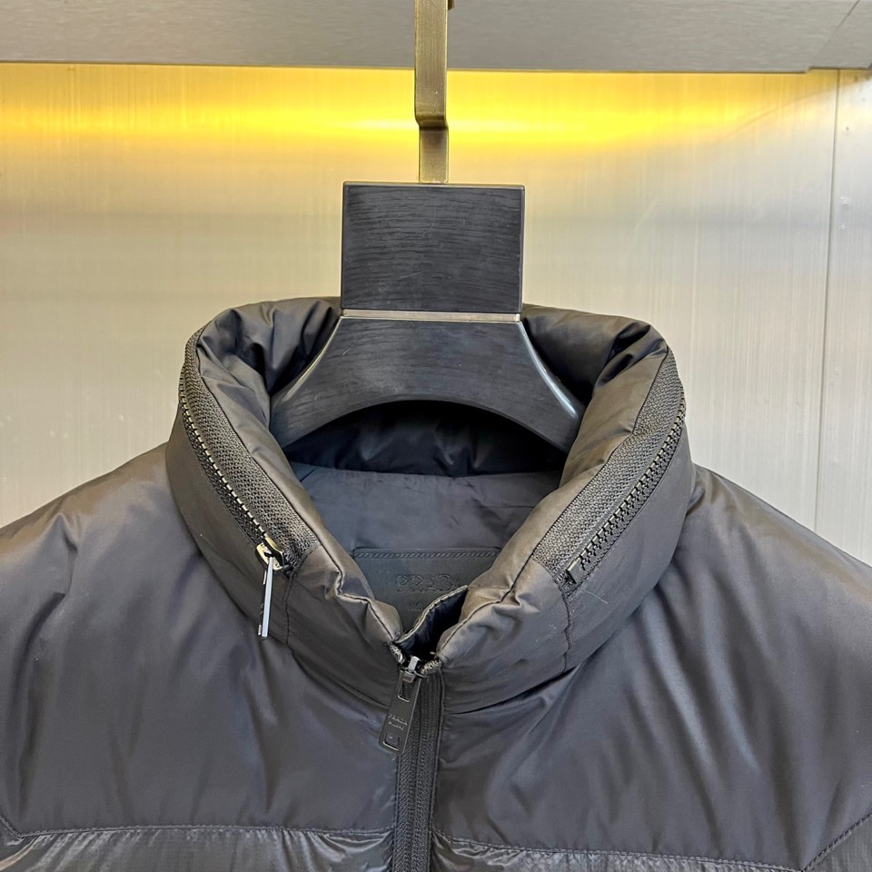 Prad普拉达、2025秋冬新品黑色羽绒马甲以简约设计诠释现代奢华。立领造型搭配顺滑拉链开合，勾勒出利落