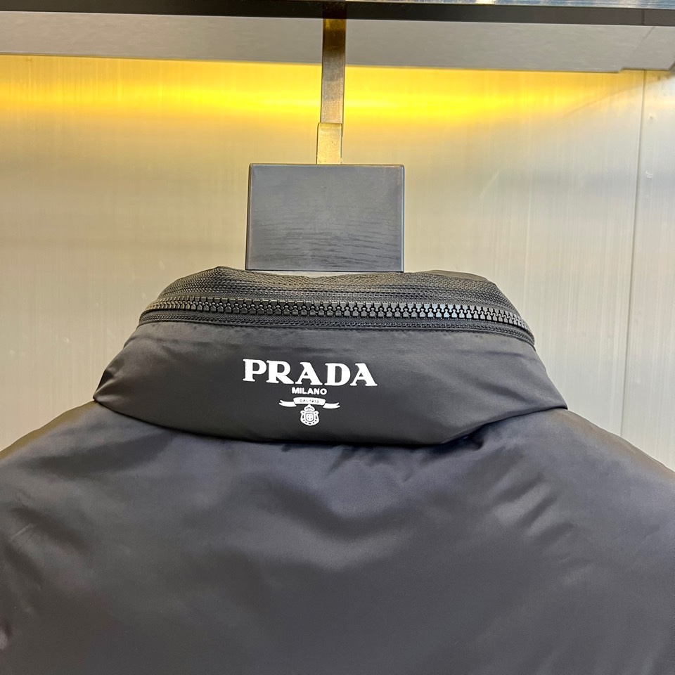Prad普拉达、2025秋冬新品黑色羽绒马甲以简约设计诠释现代奢华。立领造型搭配顺滑拉链开合，勾勒出利落