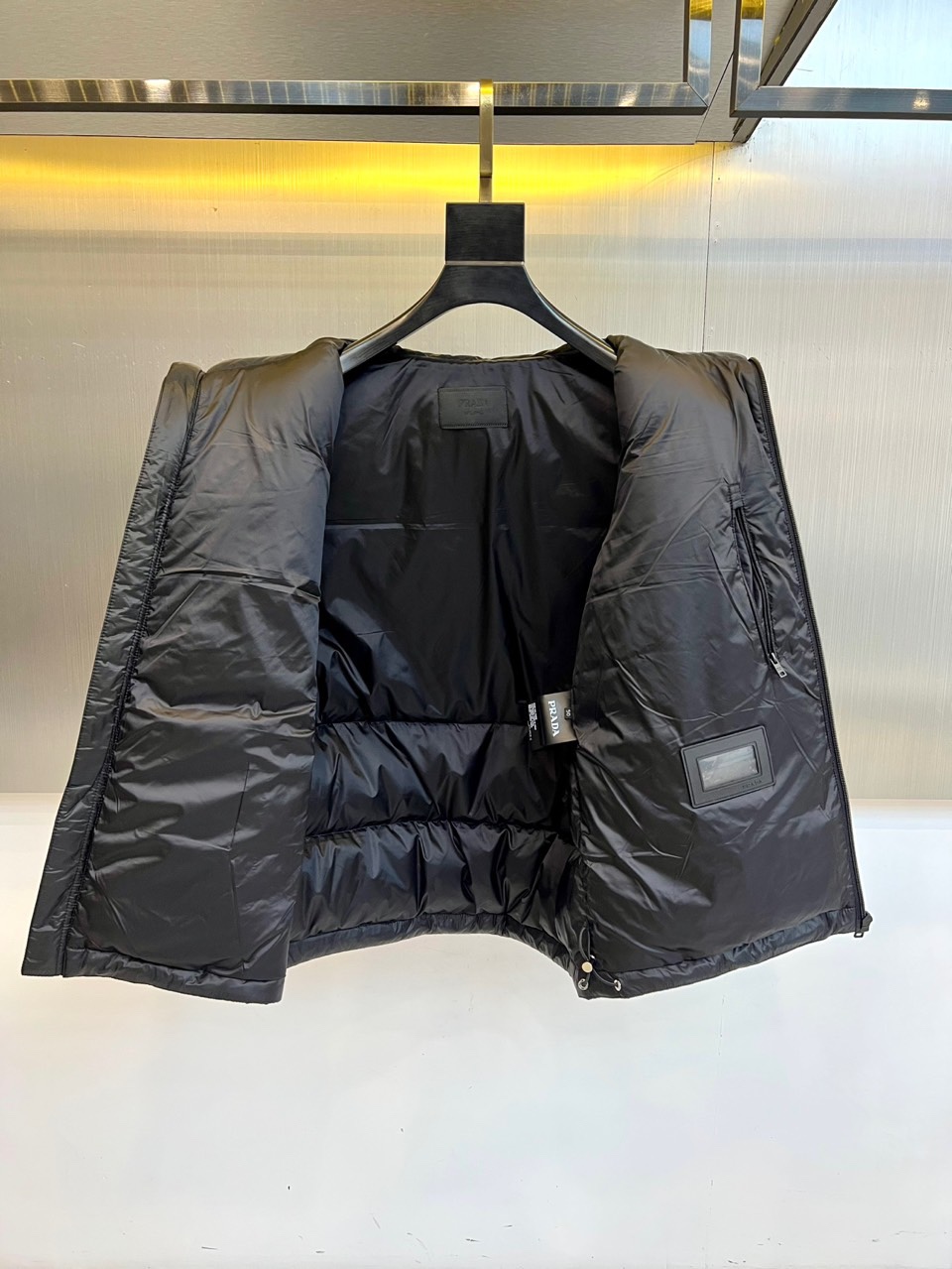 Prad普拉达、2025秋冬新品黑色羽绒马甲以简约设计诠释现代奢华。立领造型搭配顺滑拉链开合，勾勒出利落