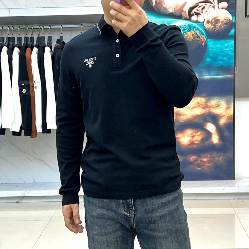 Prad普拉达、2025秋冬新品长袖Polo衫，经典翻领设计缀以黑蓝相间条纹边饰，领口下三颗米白色纽扣延