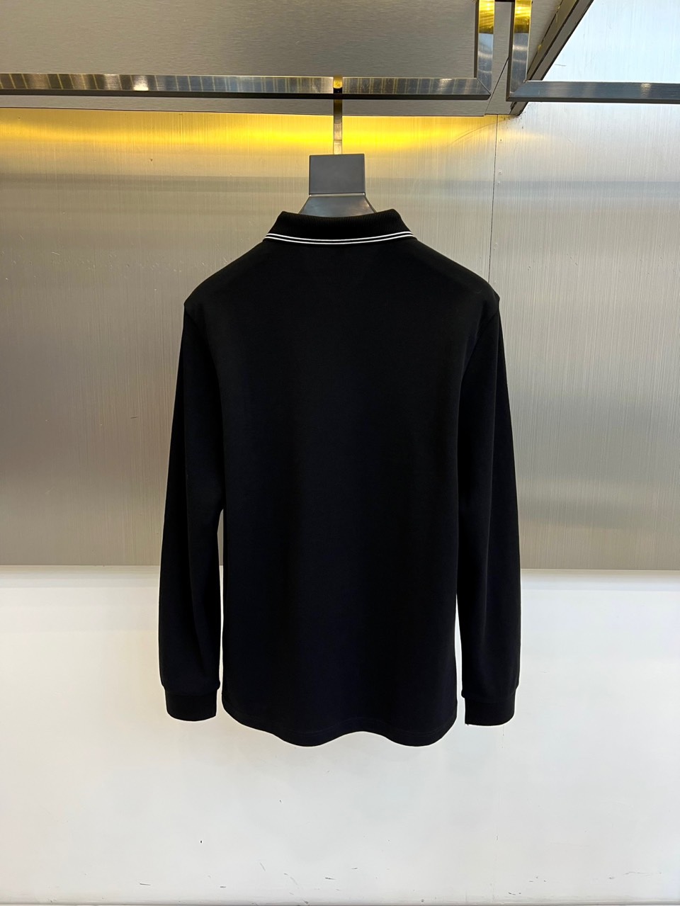 Prad普拉达、2025秋冬新品长袖Polo衫，经典翻领设计缀以黑蓝相间条纹边饰，领口下三颗米白色纽扣延