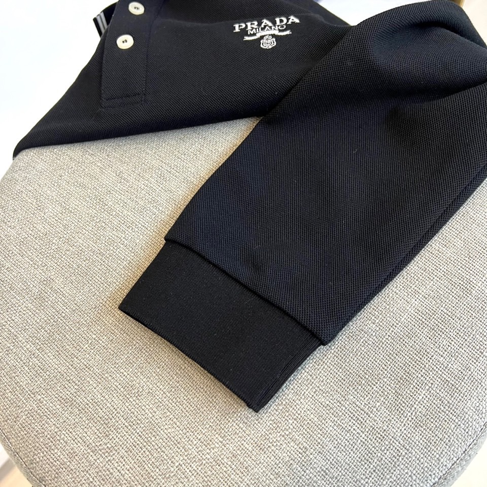 Prad普拉达、2025秋冬新品长袖Polo衫，经典翻领设计缀以黑蓝相间条纹边饰，领口下三颗米白色纽扣延