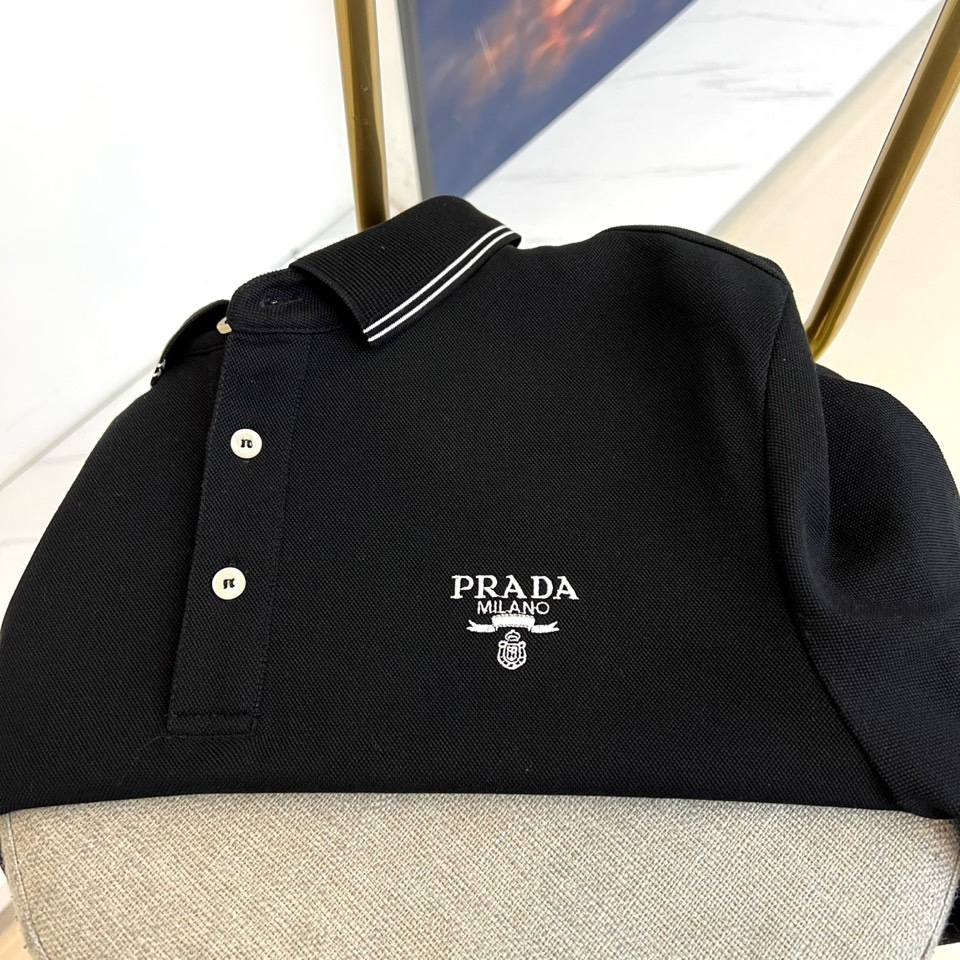 Prad普拉达、2025秋冬新品长袖Polo衫，经典翻领设计缀以黑蓝相间条纹边饰，领口下三颗米白色纽扣延