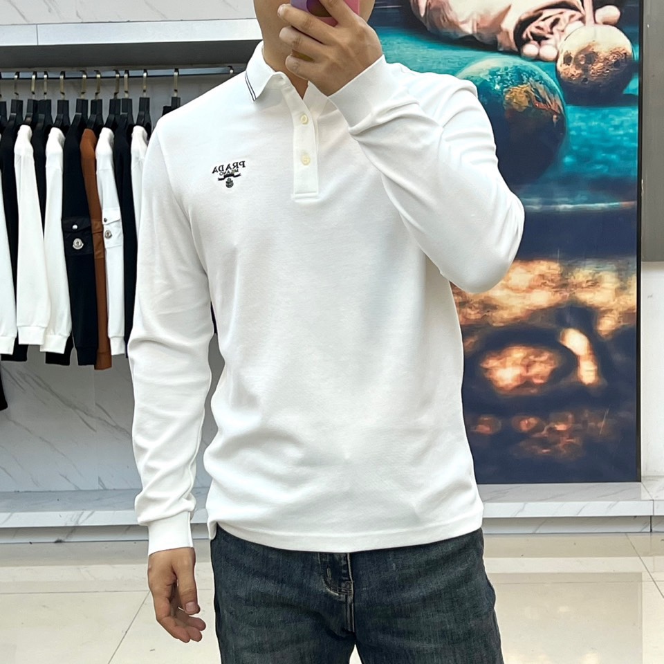 Prad普拉达、2025秋冬新品长袖Polo衫，经典翻领设计缀以黑蓝相间条纹边饰，领口下三颗米白色纽扣延