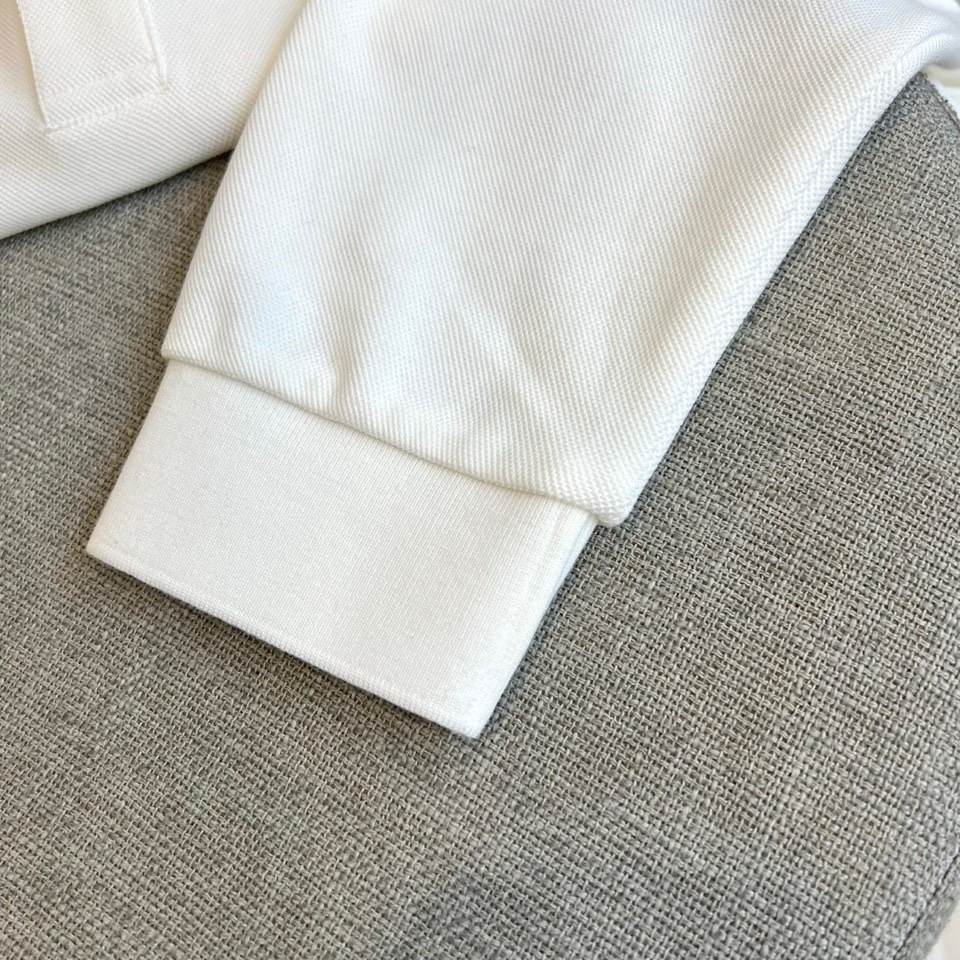 Prad普拉达、2025秋冬新品长袖Polo衫，经典翻领设计缀以黑蓝相间条纹边饰，领口下三颗米白色纽扣延