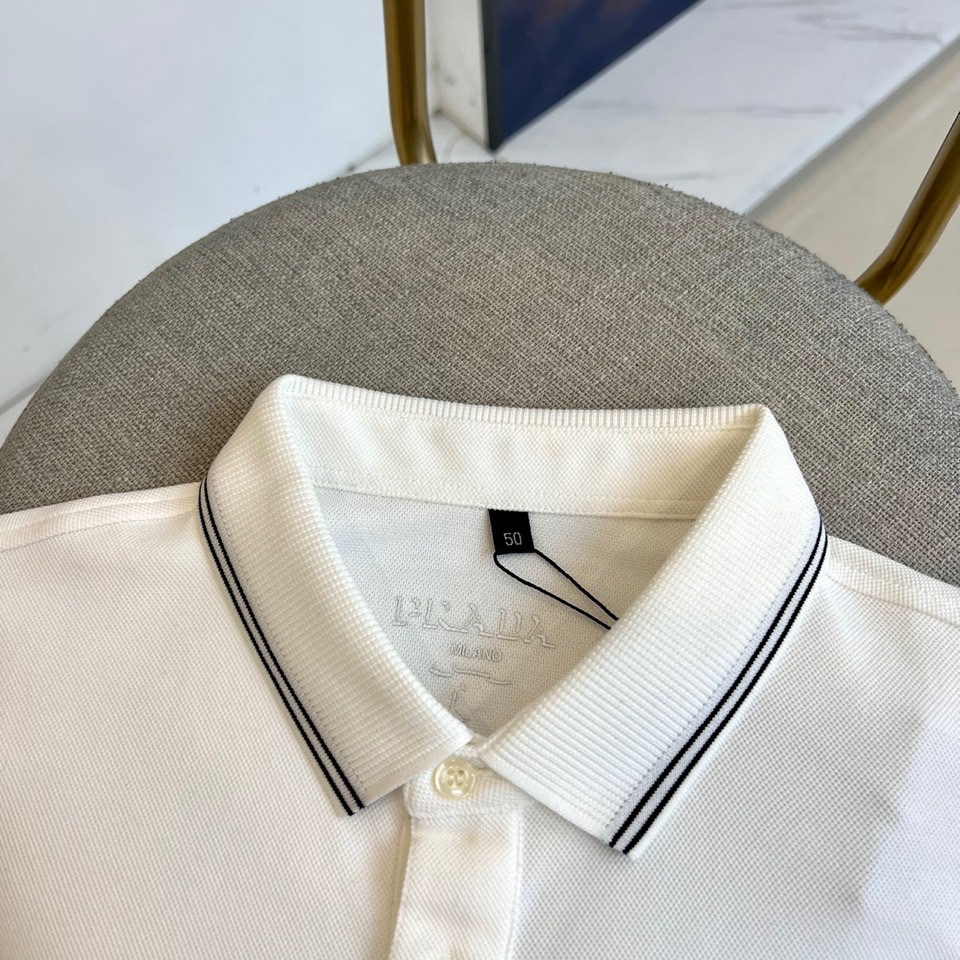 Prad普拉达、2025秋冬新品长袖Polo衫，经典翻领设计缀以黑蓝相间条纹边饰，领口下三颗米白色纽扣延