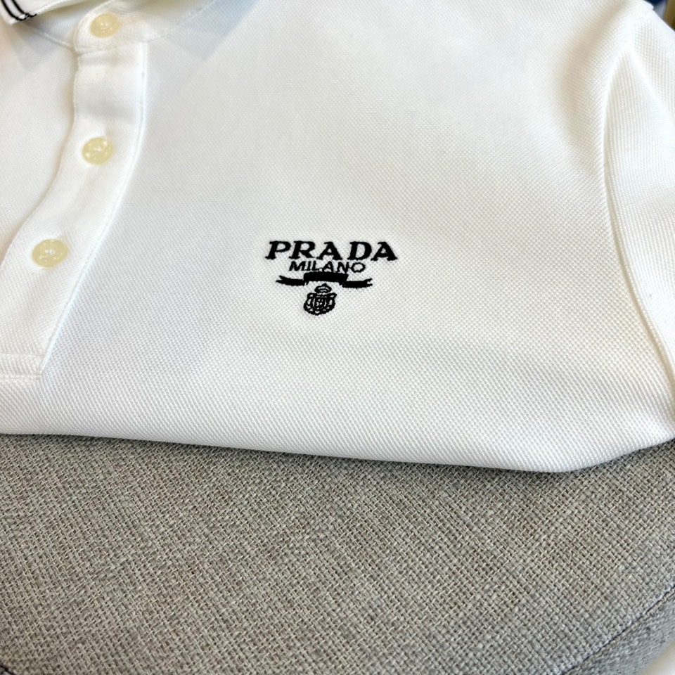 Prad普拉达、2025秋冬新品长袖Polo衫，经典翻领设计缀以黑蓝相间条纹边饰，领口下三颗米白色纽扣延