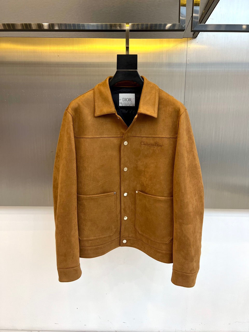 Dio迪奥、2025秋冬男士新品羽绒服外套。以质感棕色麂皮夹克诠释经典魅力。款式采用利落的翻驳领设计，勾