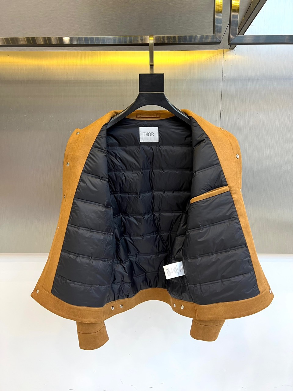 Dio迪奥、2025秋冬男士新品羽绒服外套。以质感棕色麂皮夹克诠释经典魅力。款式采用利落的翻驳领设计，勾