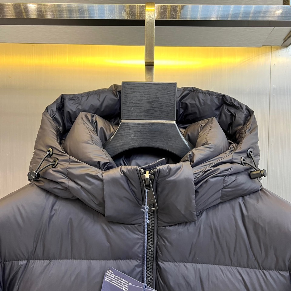 Prad普拉达、2025秋冬新品，黑色羽绒服诠释简约奢华的冬日美学。款式采用流畅的过膝廓形，搭配连帽设计