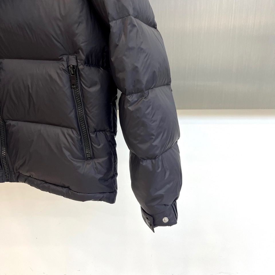 Prad普拉达、2025秋冬新品，黑色羽绒服诠释简约奢华的冬日美学。款式采用流畅的过膝廓形，搭配连帽设计