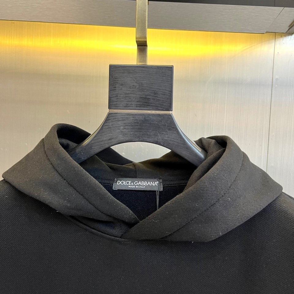 DG杜嘉班纳、2025秋冬新品加绒连帽卫衣，以纯棉质感诠释意式慵懒格调。经典连帽设计与可调抽绳，兼具实用