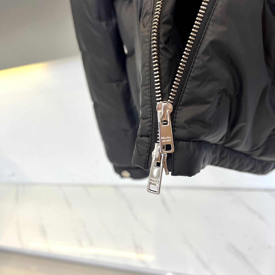 Prad普拉、2025秋冬新品 P家菱形绗缝羽绒服。黑色立领设计搭配精密拉链系统，衣身采用立体菱形绗缝工