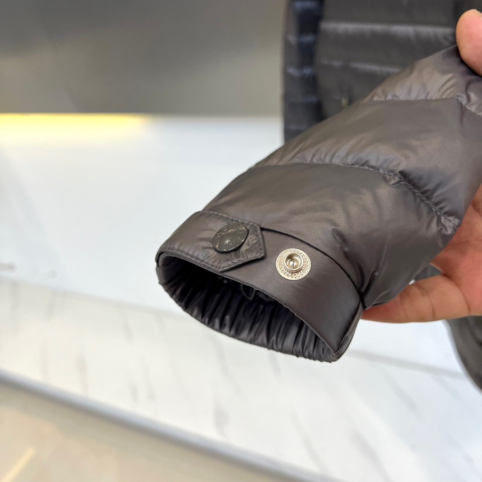 Mon蒙口（纯鹅绒）、2025秋冬新品羽绒服以深灰色调演绎现代极简美学，立领设计搭配银色拉链开合，衣身通