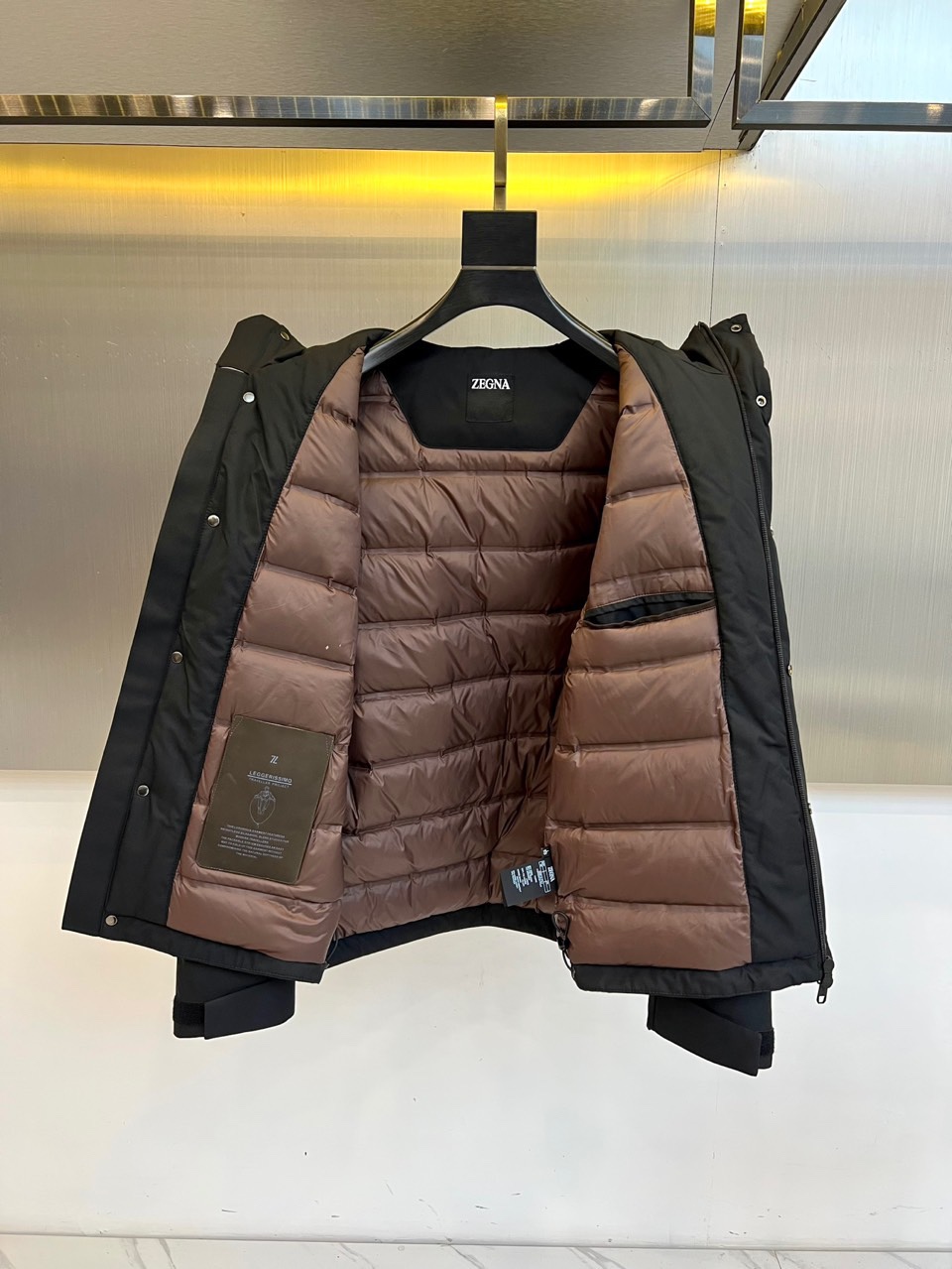 杰尼亚、（白鹅绒）2025秋冬新品黑色连帽羽绒服以极简设计诠释实用美学。连帽搭配可调节抽绳设计增强防风性