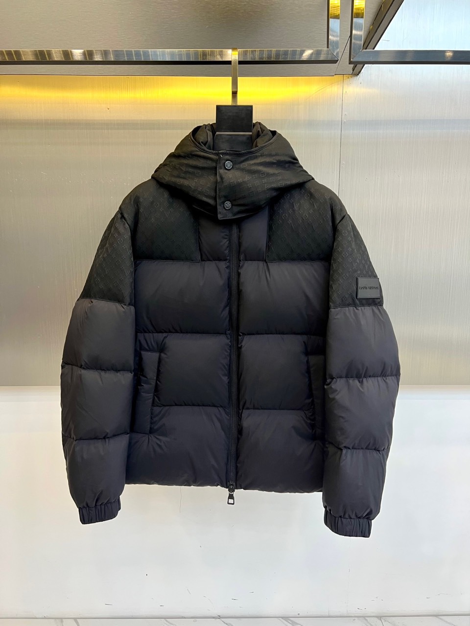 1v威登、2025秋冬新品黑色羊毛🐑羽绒服，以连帽设计演绎现代奢华。领口处点缀的纽扣细节既增强实用性，又