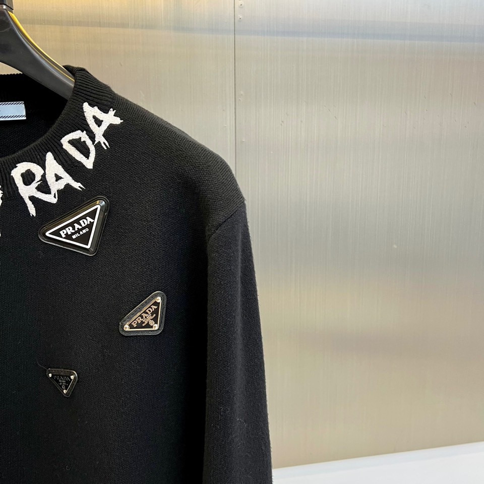 Prad普拉、2025秋冬新品白色针织毛衣，以极简主义美学诠释当代优雅。这款毛衣采用经典圆领设计，左胸位