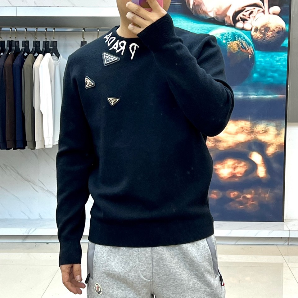 Prad普拉、2025秋冬新品白色针织毛衣，以极简主义美学诠释当代优雅。这款毛衣采用经典圆领设计，左胸位