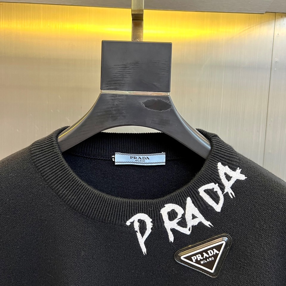 Prad普拉、2025秋冬新品白色针织毛衣，以极简主义美学诠释当代优雅。这款毛衣采用经典圆领设计，左胸位