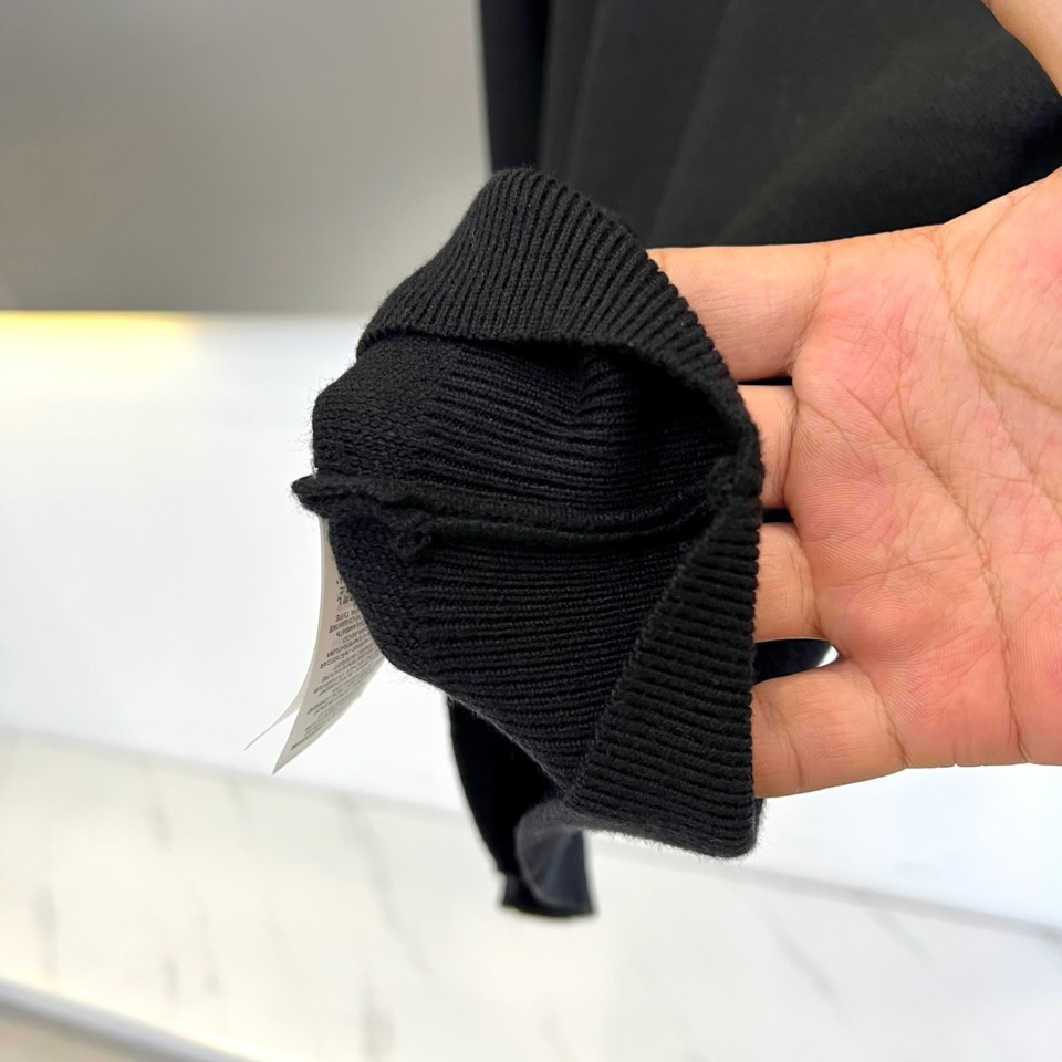 Prad普拉、2025秋冬新品白色针织毛衣，以极简主义美学诠释当代优雅。这款毛衣采用经典圆领设计，左胸位