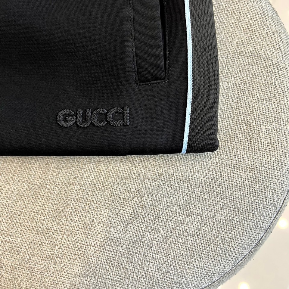 GUCC古驰、2025秋冬运动系列。2025秋冬全新运动套装，以深邃哑光黑为画布，袖管与裤侧的蓝白条纹如