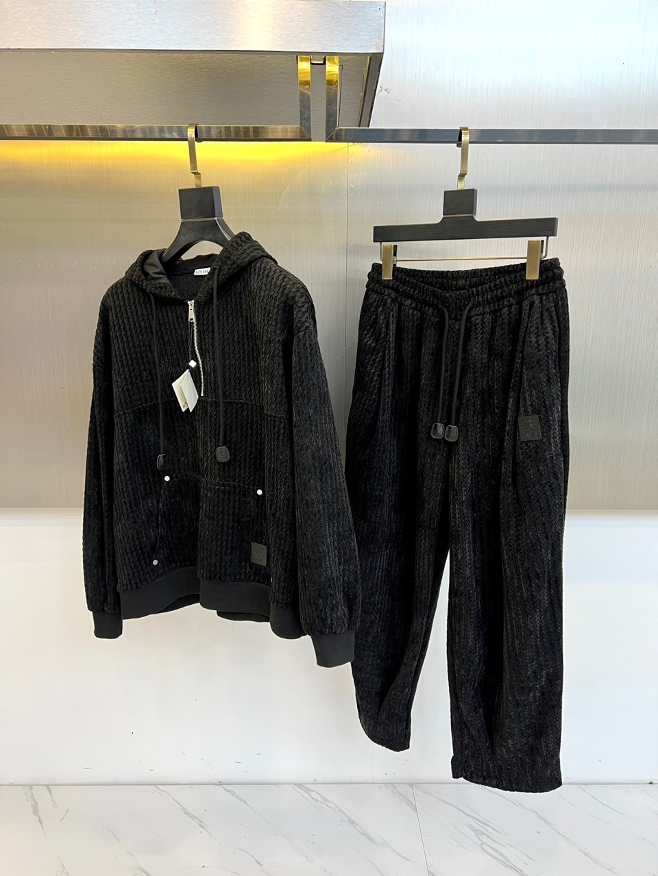 罗意威（LOEWE）套装，以经典的黑白千鸟格纹贯穿始终，将复古优雅与现代时尚感精妙结合。连帽上衣的千鸟格