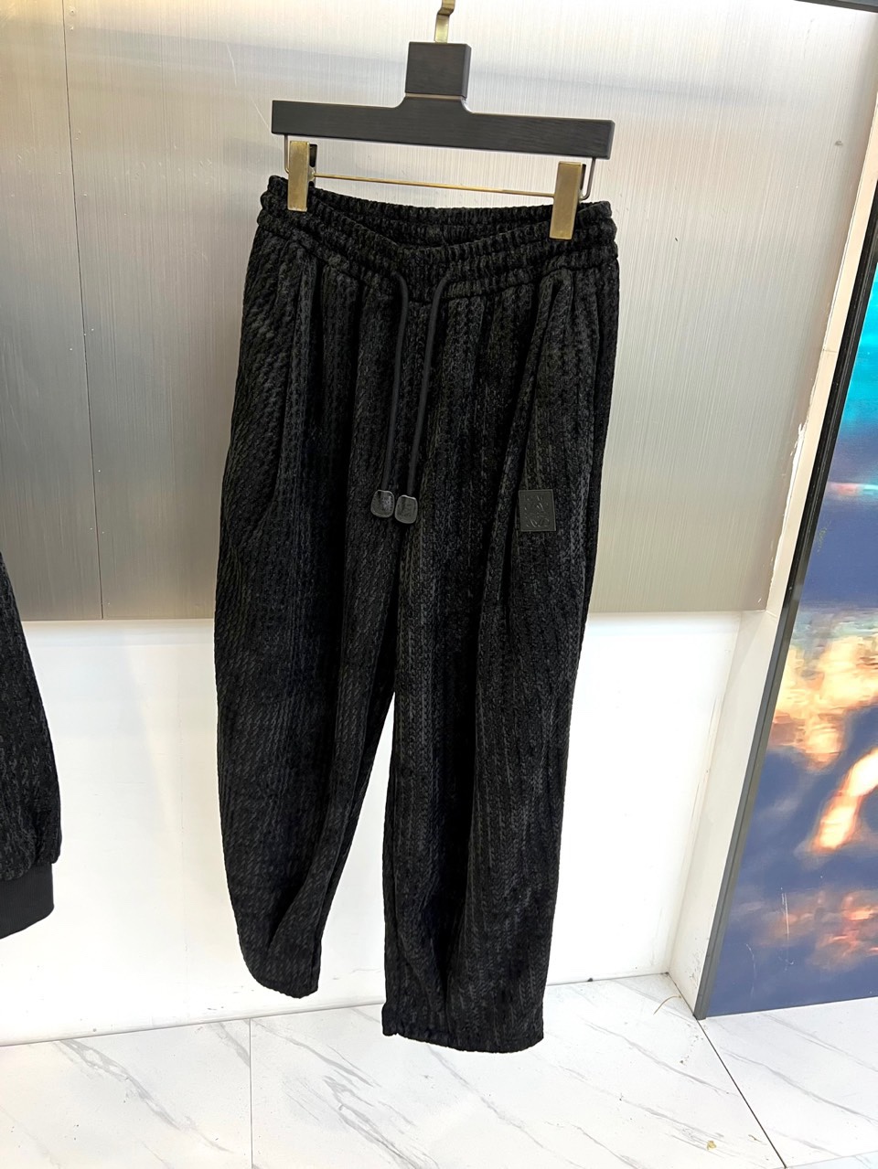 罗意威（LOEWE）套装，以经典的黑白千鸟格纹贯穿始终，将复古优雅与现代时尚感精妙结合。连帽上衣的千鸟格