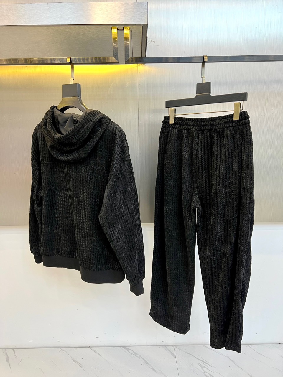 罗意威（LOEWE）套装，以经典的黑白千鸟格纹贯穿始终，将复古优雅与现代时尚感精妙结合。连帽上衣的千鸟格