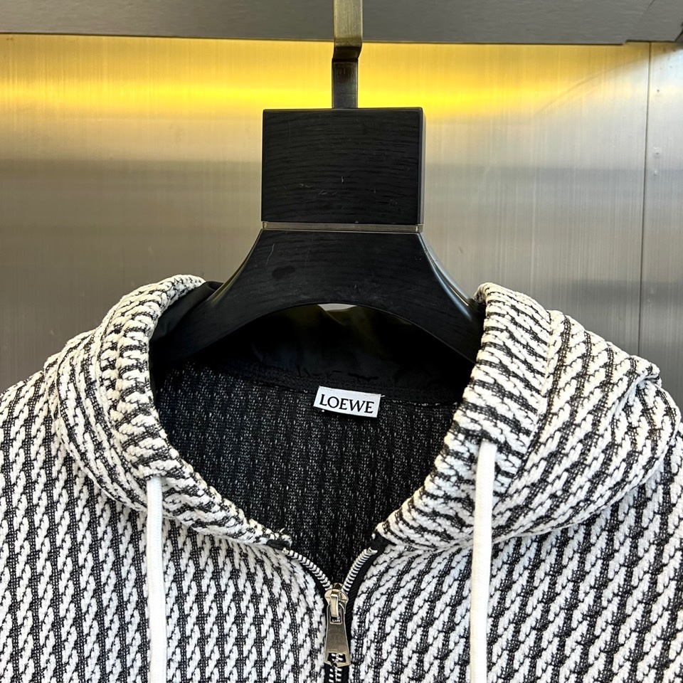 罗意威（LOEWE）套装，以经典的黑白千鸟格纹贯穿始终，将复古优雅与现代时尚感精妙结合。连帽上衣的千鸟格