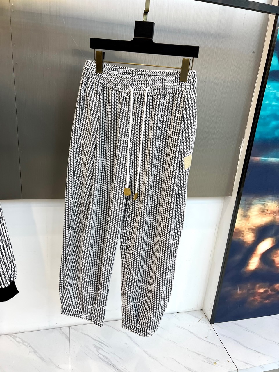 罗意威（LOEWE）套装，以经典的黑白千鸟格纹贯穿始终，将复古优雅与现代时尚感精妙结合。连帽上衣的千鸟格