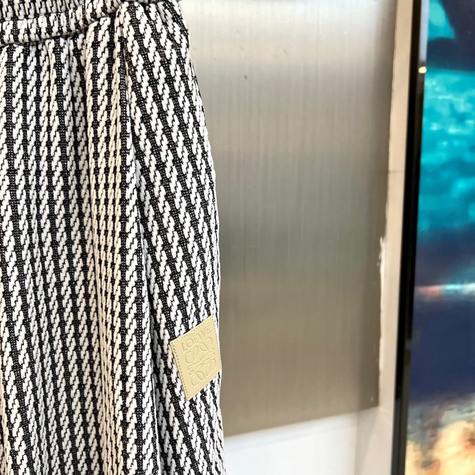 罗意威（LOEWE）套装，以经典的黑白千鸟格纹贯穿始终，将复古优雅与现代时尚感精妙结合。连帽上衣的千鸟格