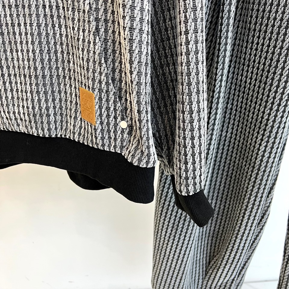 罗意威（LOEWE）套装，以经典的黑白千鸟格纹贯穿始终，将复古优雅与现代时尚感精妙结合。连帽上衣的千鸟格