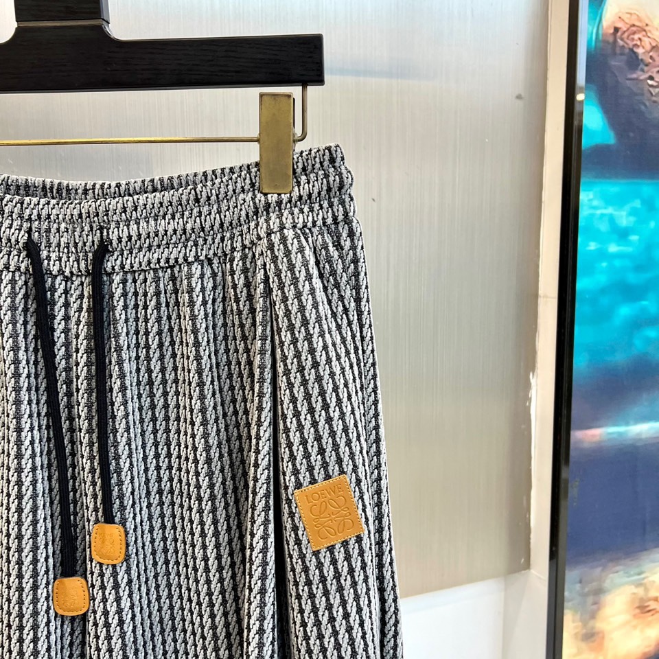 罗意威（LOEWE）套装，以经典的黑白千鸟格纹贯穿始终，将复古优雅与现代时尚感精妙结合。连帽上衣的千鸟格