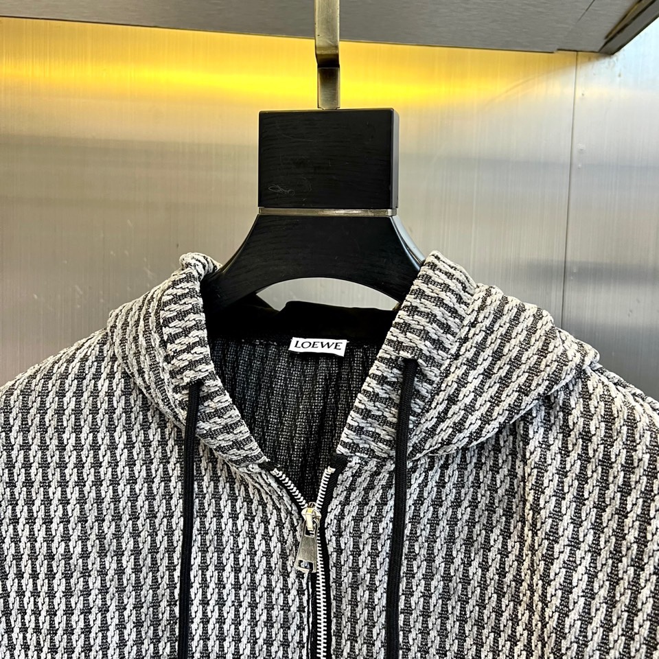 罗意威（LOEWE）套装，以经典的黑白千鸟格纹贯穿始终，将复古优雅与现代时尚感精妙结合。连帽上衣的千鸟格
