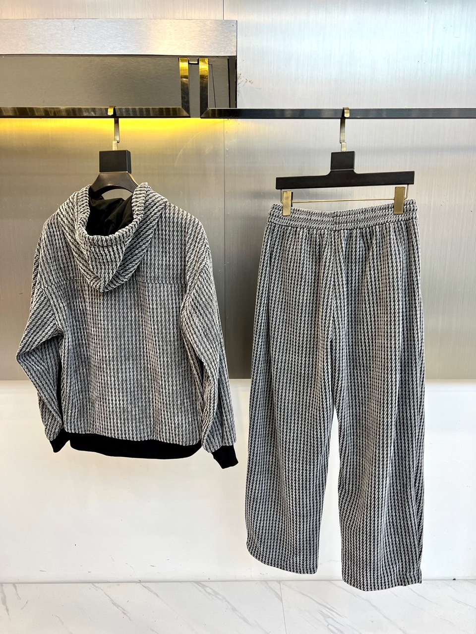 罗意威（LOEWE）套装，以经典的黑白千鸟格纹贯穿始终，将复古优雅与现代时尚感精妙结合。连帽上衣的千鸟格